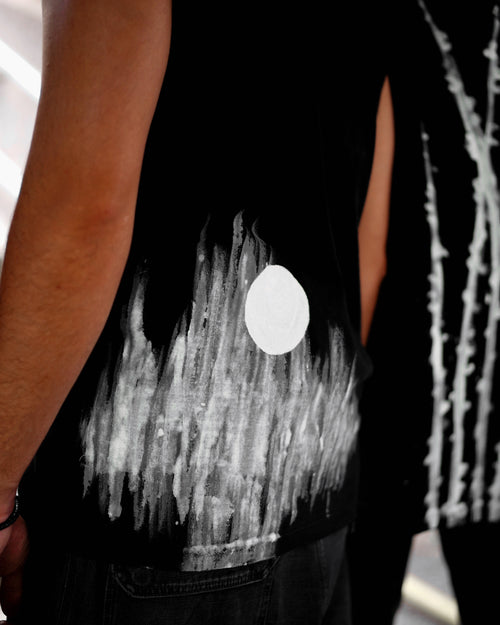 Black sleeveless top with white abstract design on a blurred background